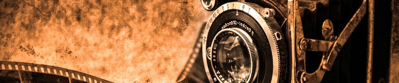 Eine alte Kamera mit einem Super 8 Film im Hintergrund